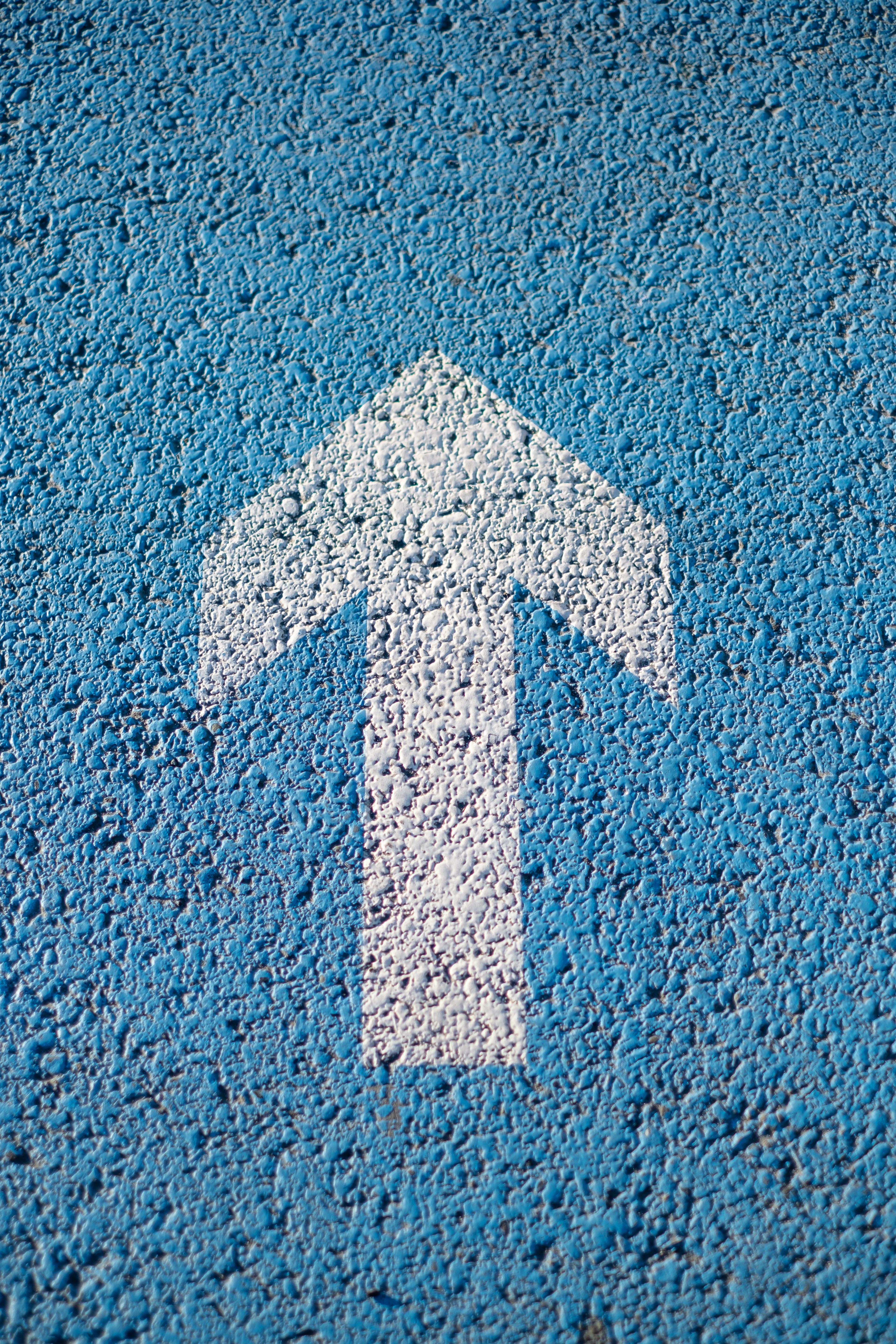 Weißer Pfeil auf hellblauem Huntergrund